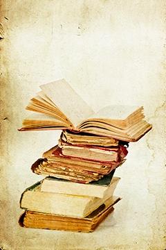 A pile of books, one of them is opened.