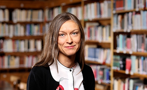 Jessica Sjöholm Skrubbe framför en vägg med böcker